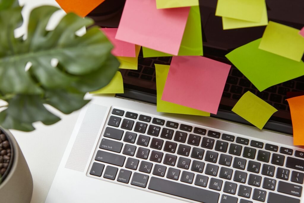 Entrepreneur organizing tasks and notes using digital workspace tools on laptop